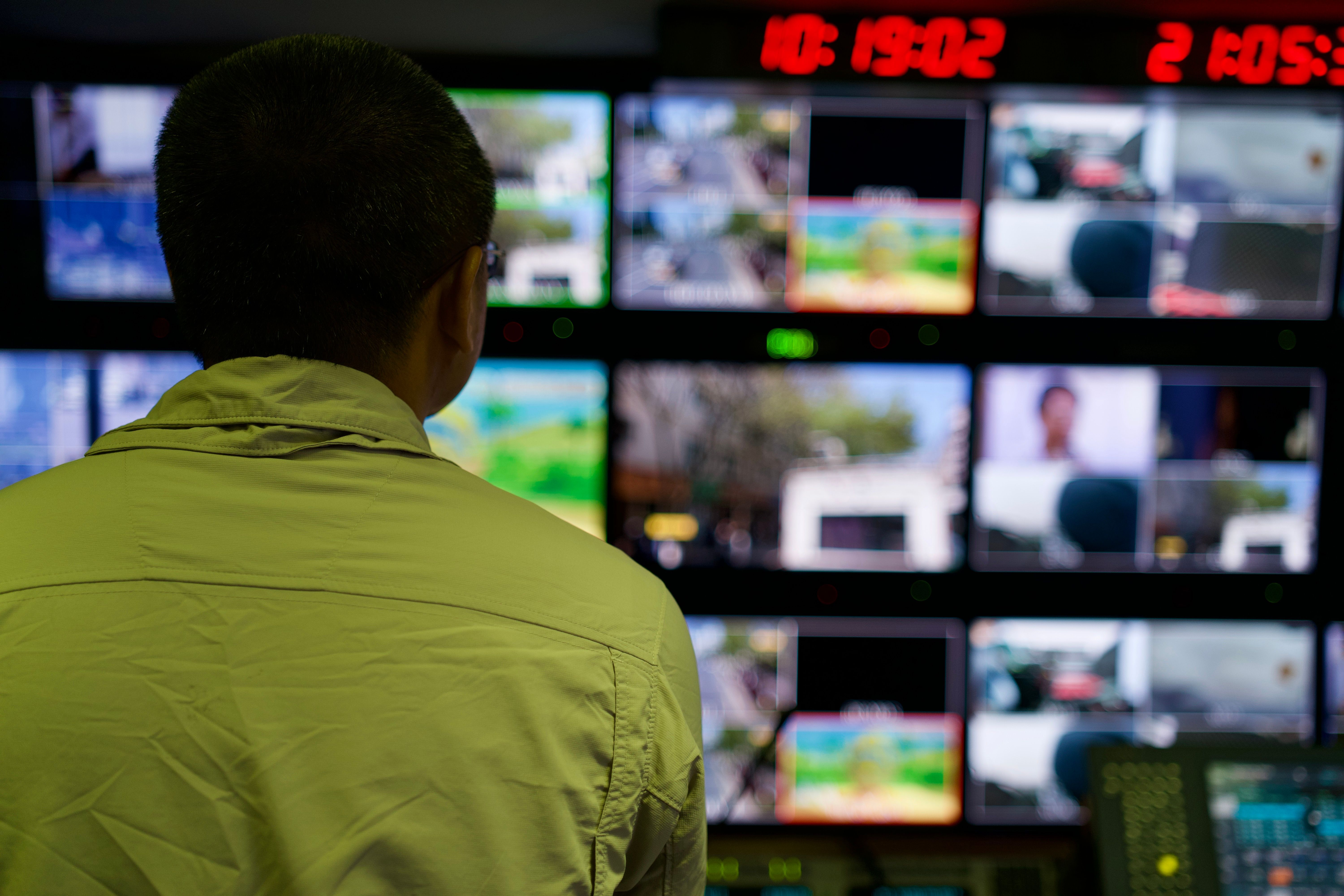 An operator monitoring multiple screens in a security control room.