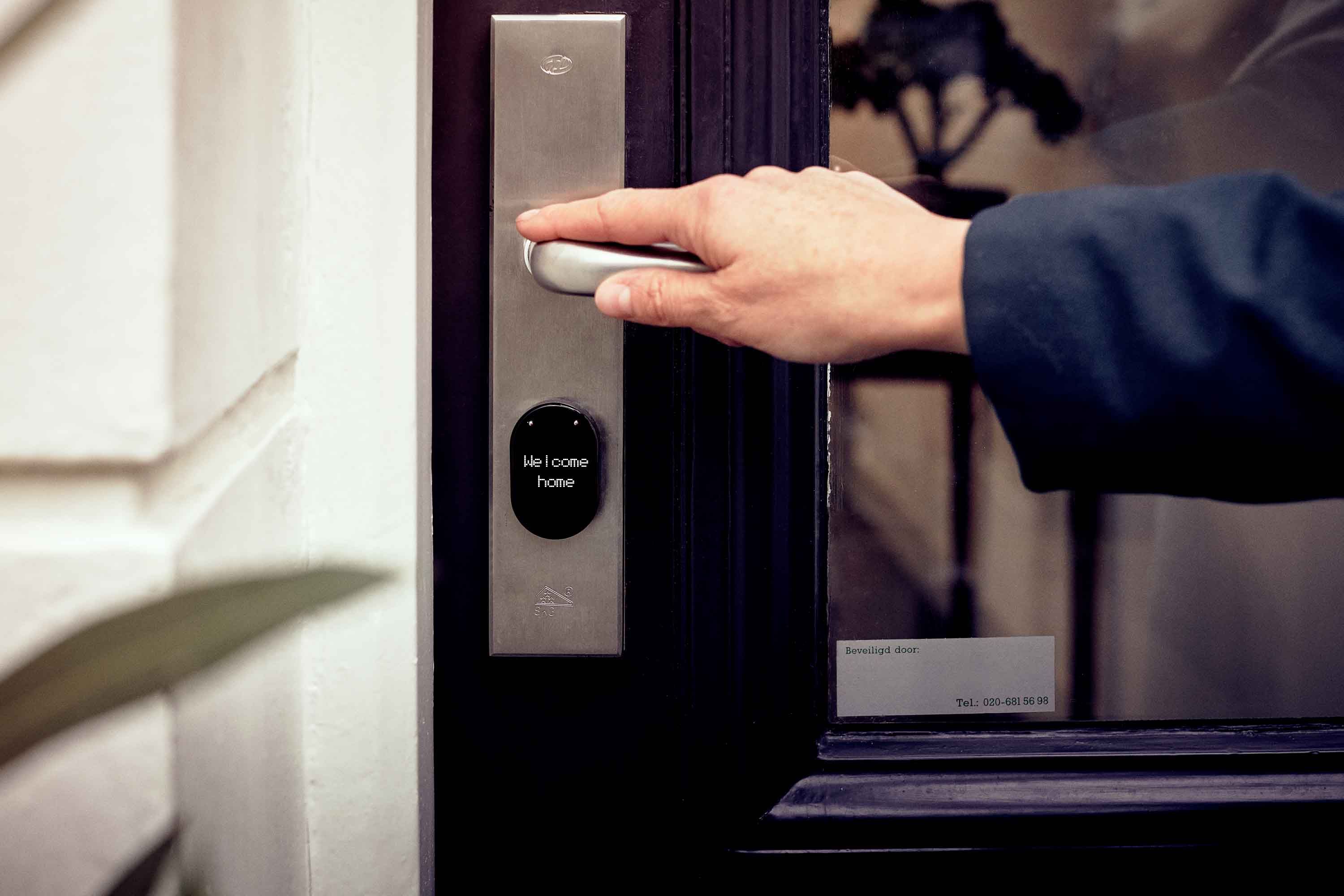 Hand using a smart access panel on a home door